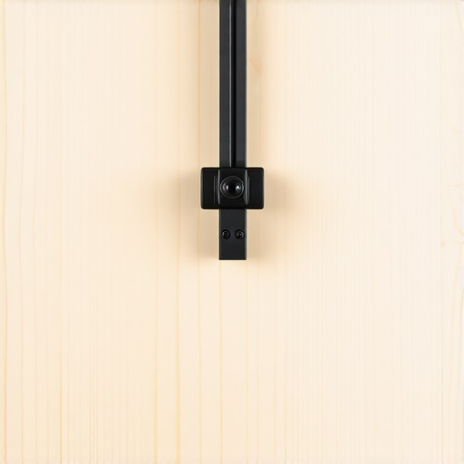 Close-up of a birch plywood plate used to distribute pressure and stabilize a camera mount on a desk.