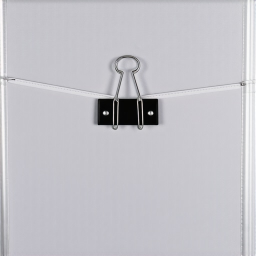 Tensioning fabric backdrop with binder clips A close-up of a metal binder clip clamping fabric to a studio stand to eliminate wrinkles.